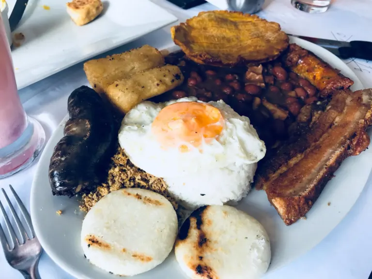 A bandeja paisa, the Colombian platter of beans, rice, fried egg, chicharrón, sausage and arepas